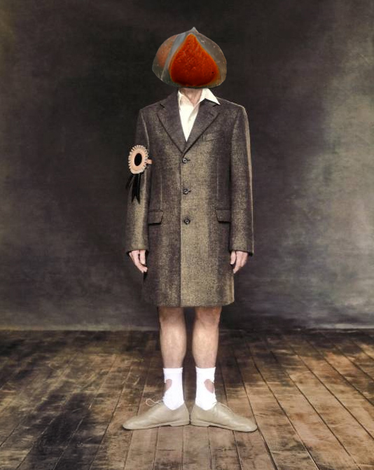 willem dafoe standing in gray suit and heart socks